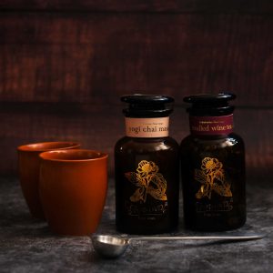 Photo of two jars of tea - Yogi Chai Masala and Mulled Wine Tea - with two kulhar chai cups and a serving spoon, all contained in Tchai-Ovna's Spiced Tea Hamper