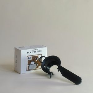 A photo of a tea clip and a box of tea filters
